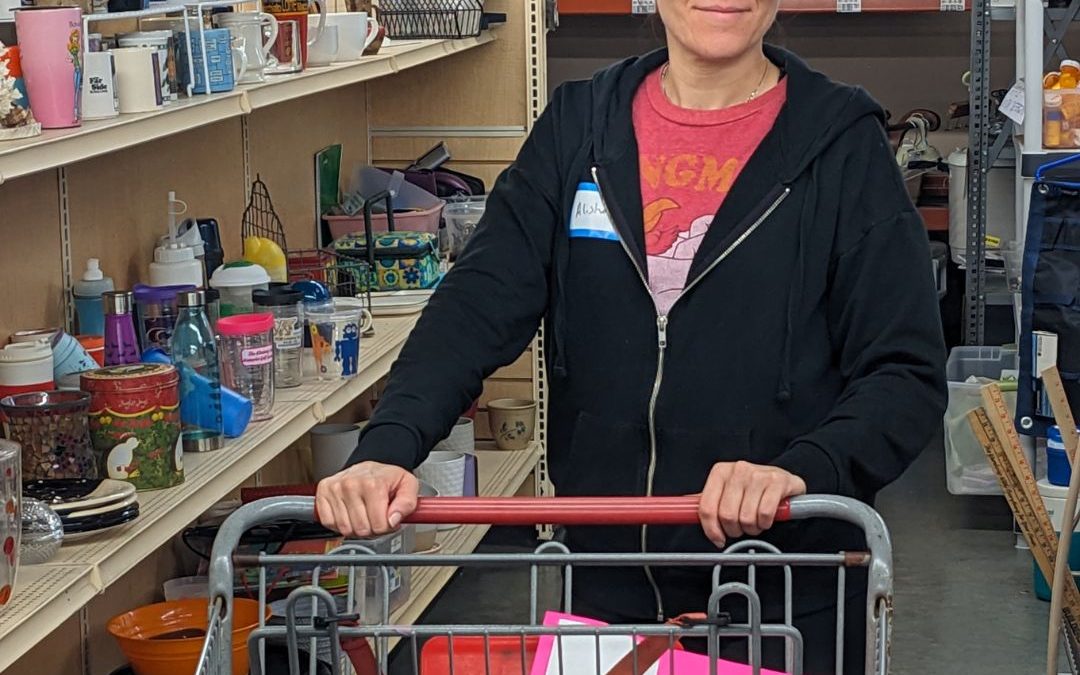 Alisha stands smiling with a shopping cart in the decor aisle