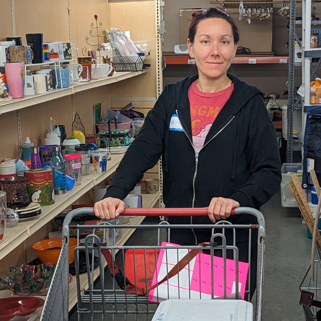 Alisha stands smiling with a shopping cart in the decor aisle