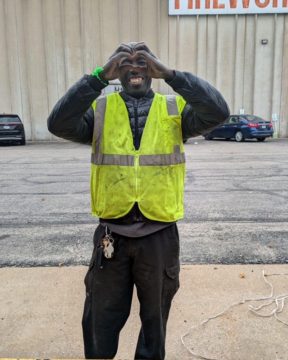 Nadia's brother Emanuel makes a heart with his hands while helping move furniture on the Flourish dock