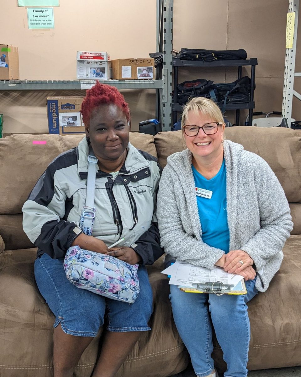 Nadia and her showroom host, Stephanie, sit on a couch